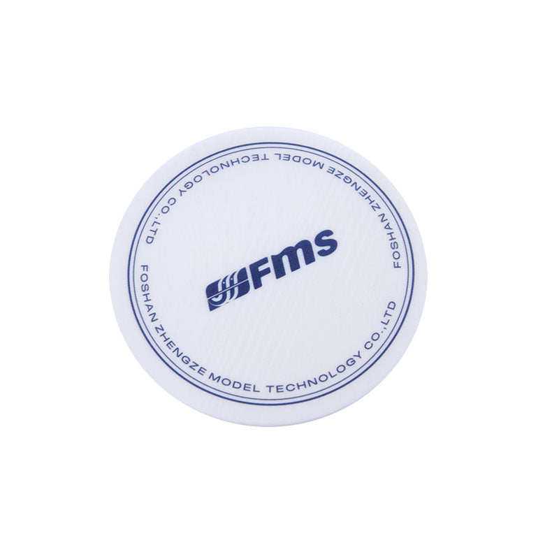Round FMS branded coaster with blue logo on white surface