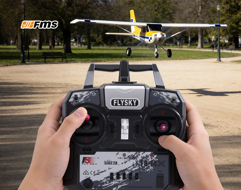 Hands holding Flysky remote control flying FMS RC plane in a park