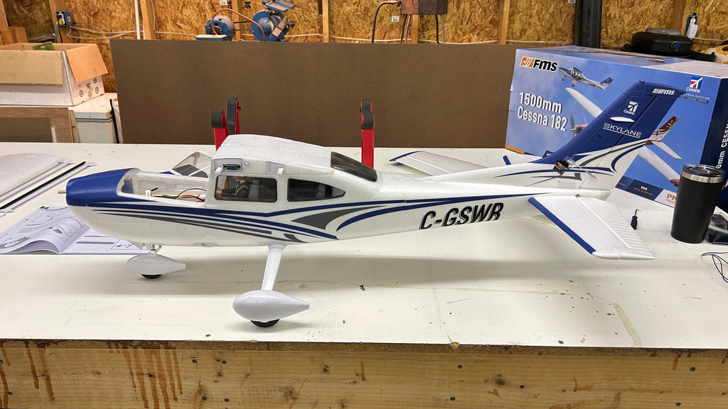 Close-up side view of FMS Cessna 182 RC plane showing C-GSWR registration and blue trim details