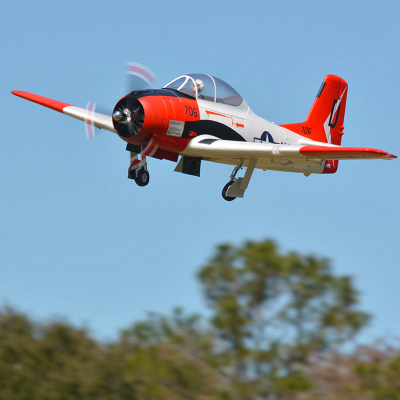 FMS 1400mm T-28D Trojan V4 Red PNP RC aircraft in flight, featuring a red and white paint scheme with '706' markings.