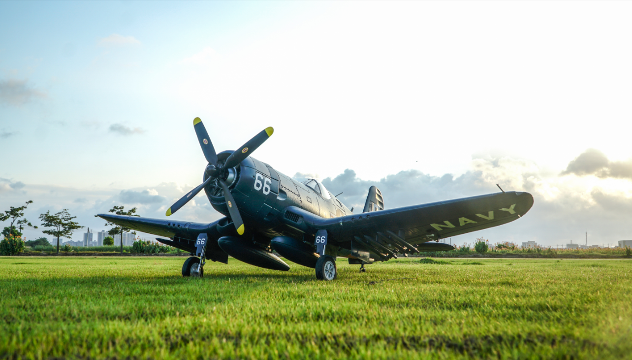 Fmshobby navy blue F4U Corsair RC plane with 66 markings and yellow-tipped propeller parked on green grass