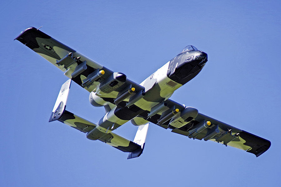 FMS 70mm A-10 Thunderbolt II V2 PNP jet with camouflage paint, weapons, and shark mouth detail flying against blue sky.