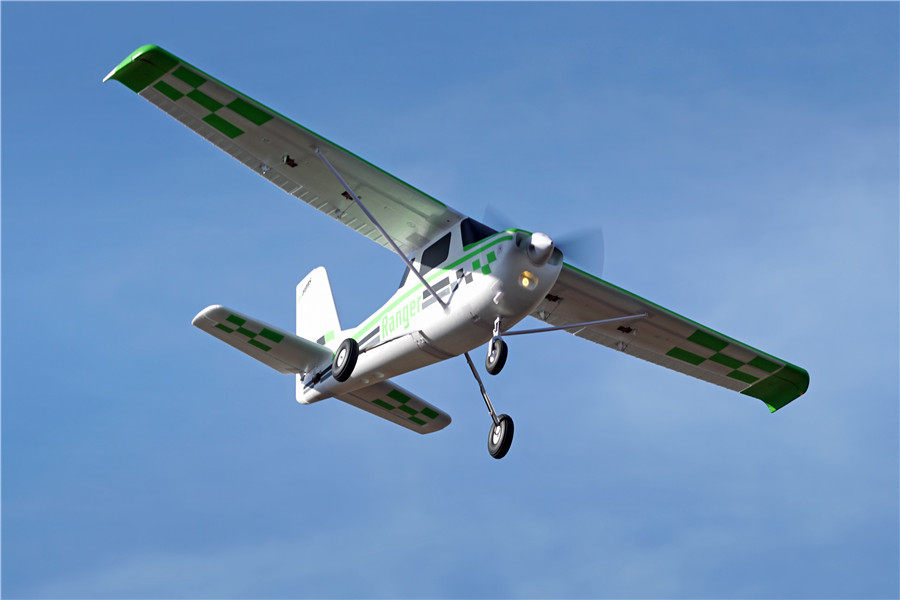 FMS 1800mm Ranger PNP remote control airplane flying against a clear blue sky.