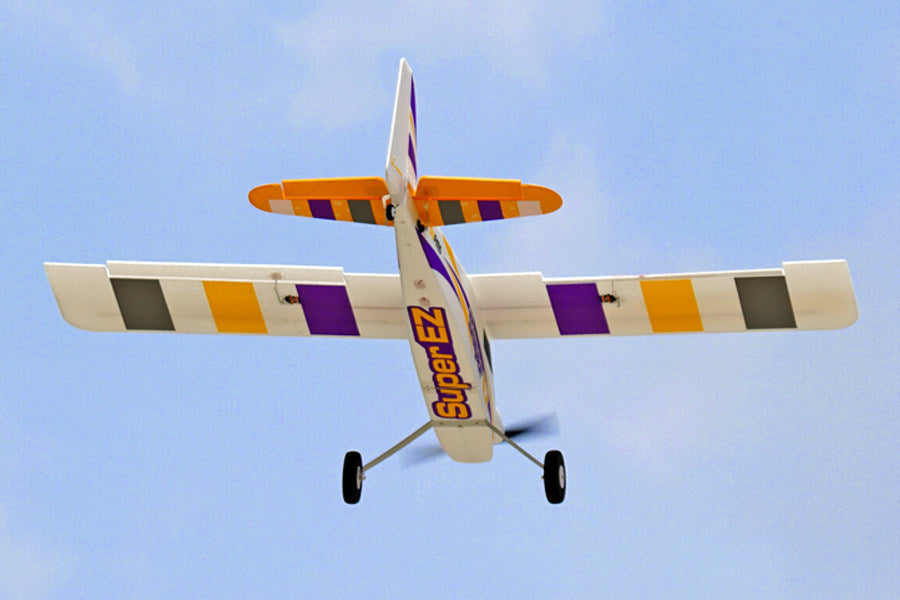 FMS 1220mm Super EZ V4 RC airplane with extended landing gear flying against a blue sky.