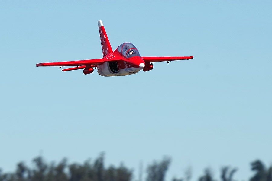 Red FMS EDF Jet Yak-130 V2 PNP model aircraft flying in clear blue sky.