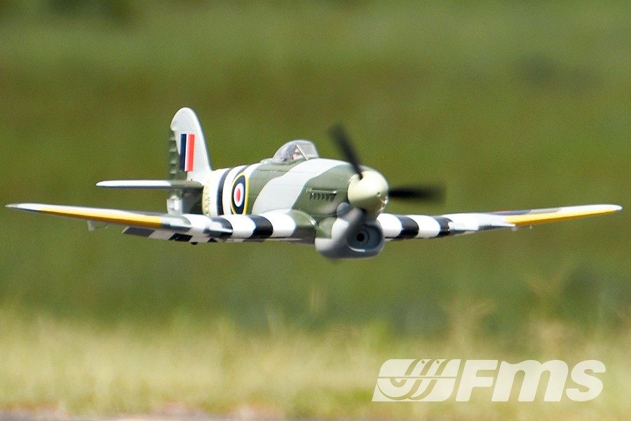 FMS 1100mm Typhoon PNP model airplane in flight, featuring British RAF markings and camouflage.
