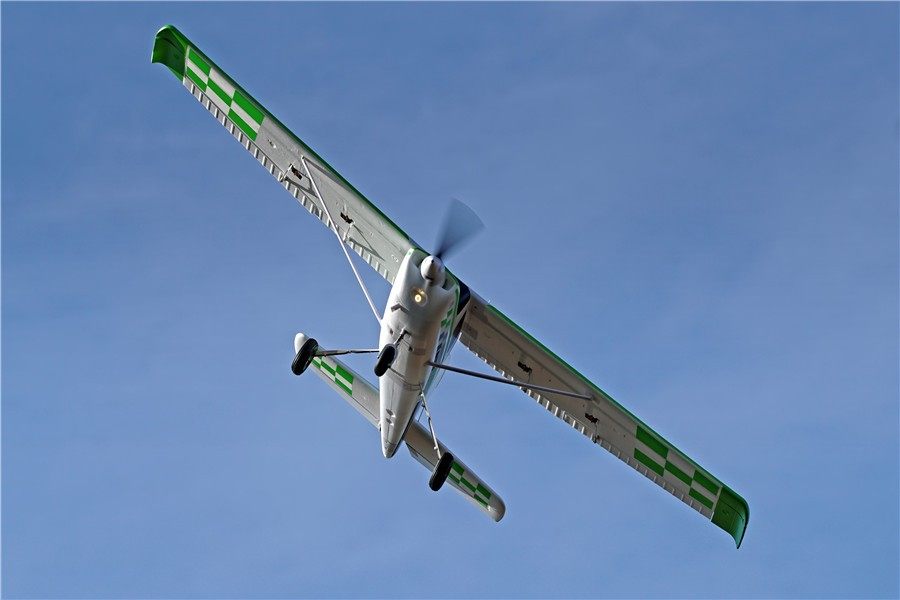 FMS 1800mm Ranger PNP model airplane in flight with green and white checkered wing accents.