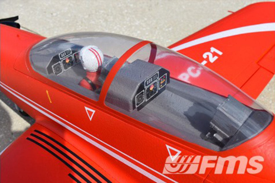 Red FMS 1100mm PC-21 Pilatus PNP RC aircraft cockpit detail with pilot figure and dashboard.
