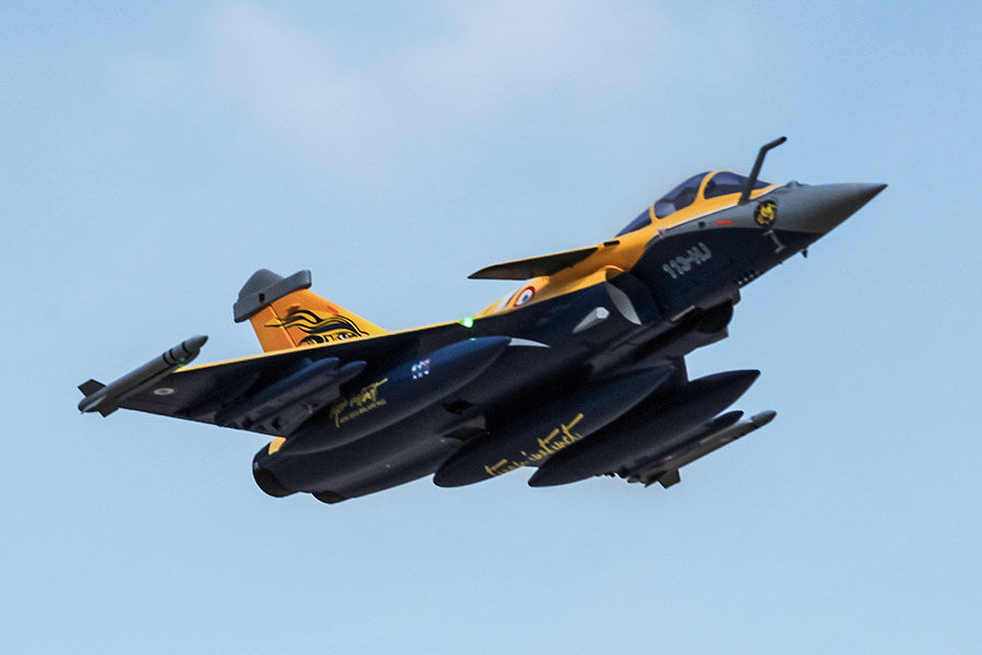 FMS 80mm Rafale jet, yellow/navy blue, in flight. Features 113-HU marking and canards.