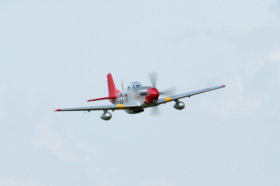 FMS 1700mm P-51D Red Tail PNP model aircraft in flight, silver with red accents and markings.