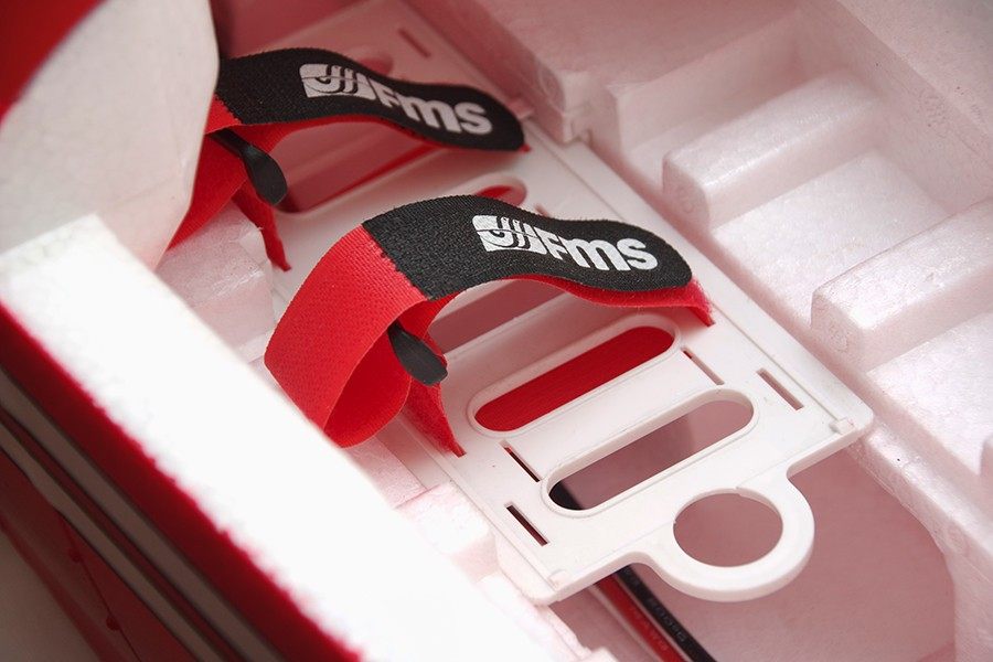 FMS Pitts V2 PNP red battery straps securing white plastic tray inside foam packaging
