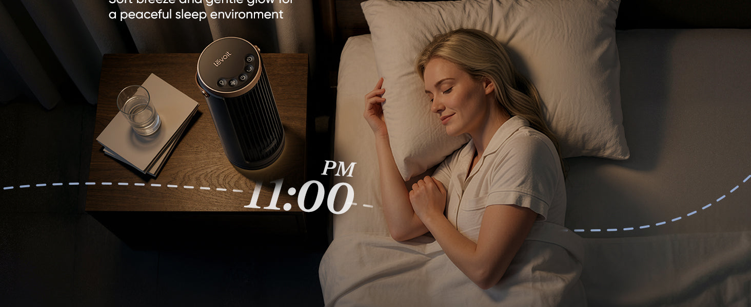 A woman peacefully sleeps in bed beside a bedside table with a glass of water and a fan, indicating a calm nighttime environment.