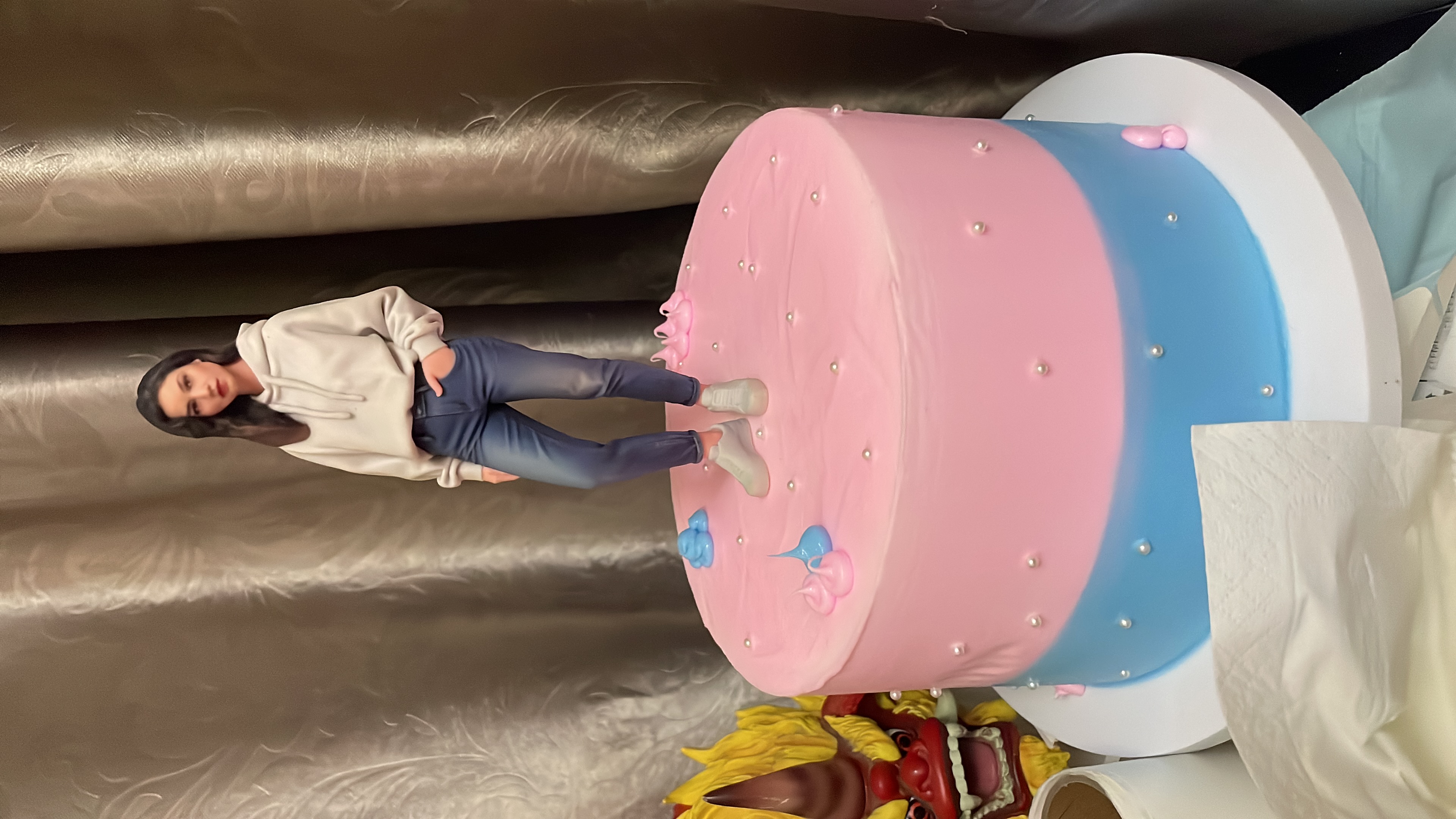 Woman figurine standing on a pink and blue cake base