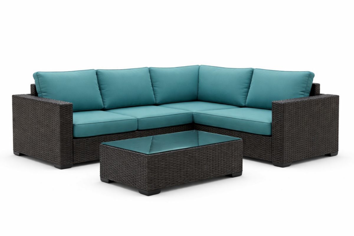 Set divano angolare da giardino in vimini con cuscini blu e tavolino in vetro