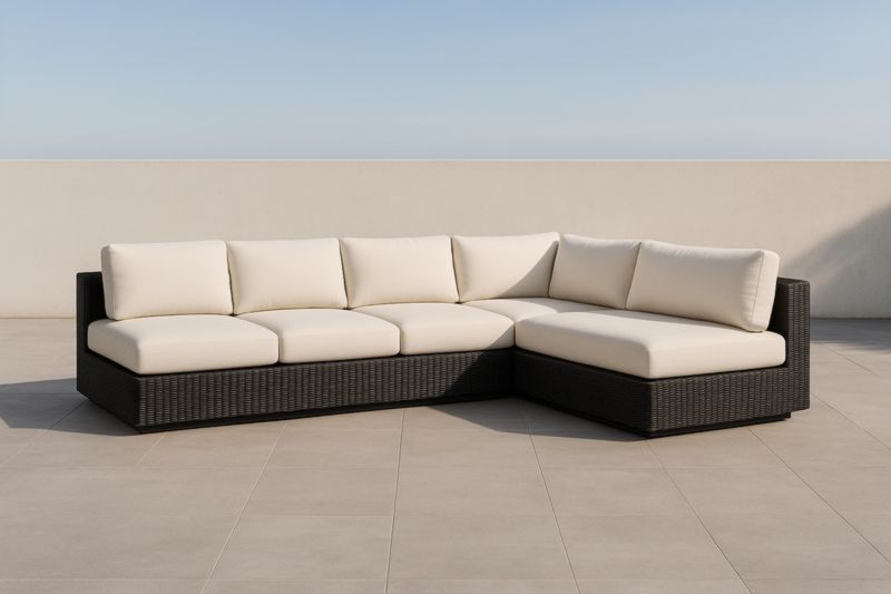 Divano ad angolo da esterno in rattan sintetico con cuscini bianchi