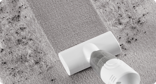 Close-up of a white plastic tube, likely for toothpaste or cosmetics, with product squeezed out onto a textured gray surface.