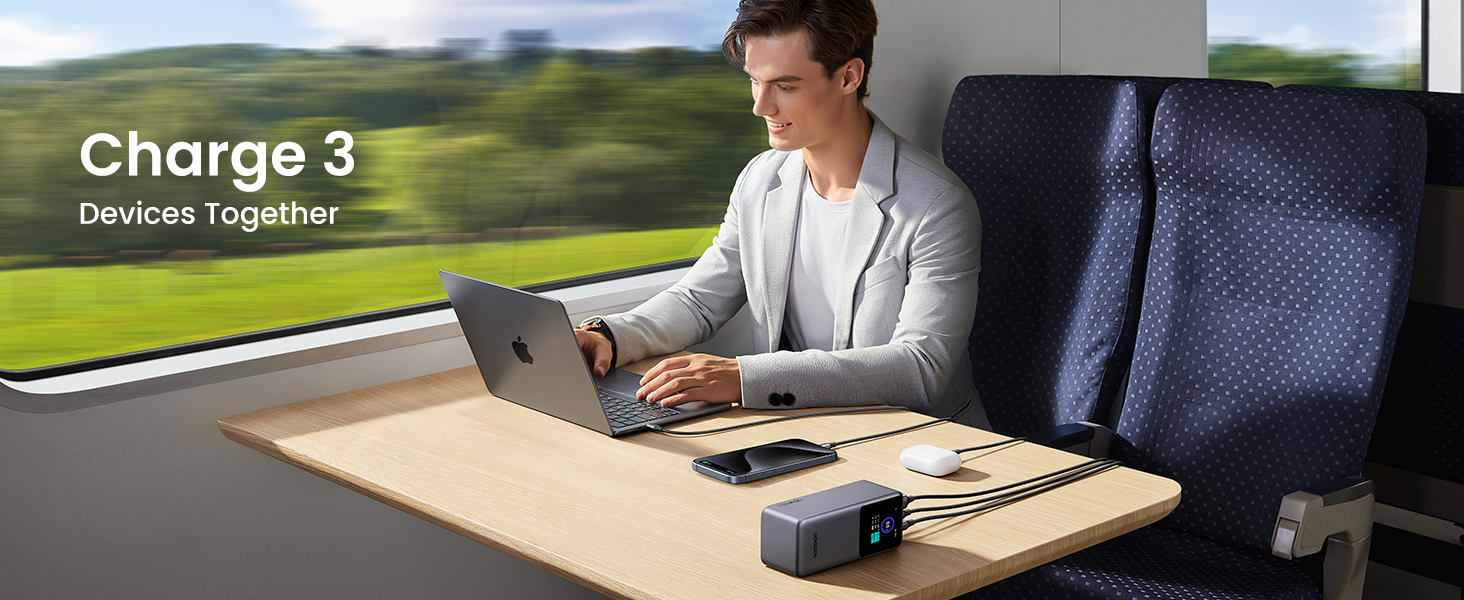 Man using UGREEN Nexode Power Bank 20000mAh 130W on train Charges 3 devices - laptop, cell phone and earbuds