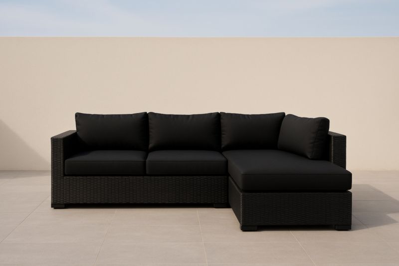 Divano ad angolo in rattan sintetico con cuscini in tessuto nero