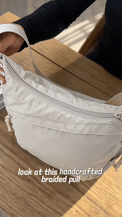 Open bag showing it holds iPad, notebook, umbrella, phone, glasses, passport, skincare, lipstick, tissue