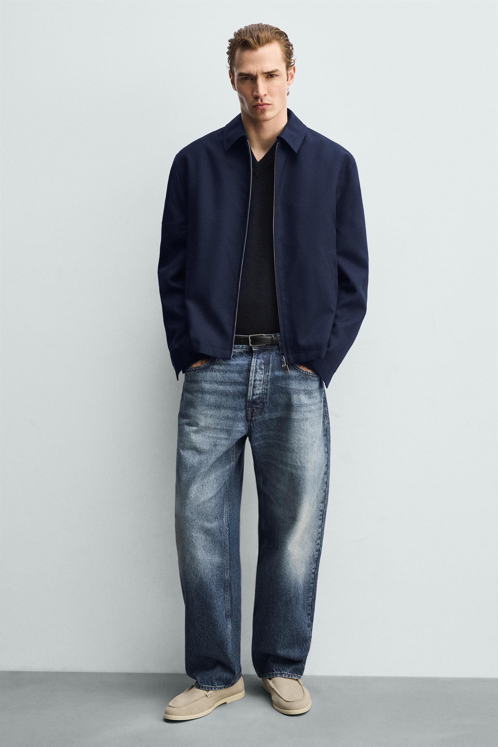 Navy blue jacket, black t-shirt, distressed blue jeans, and loafers.
