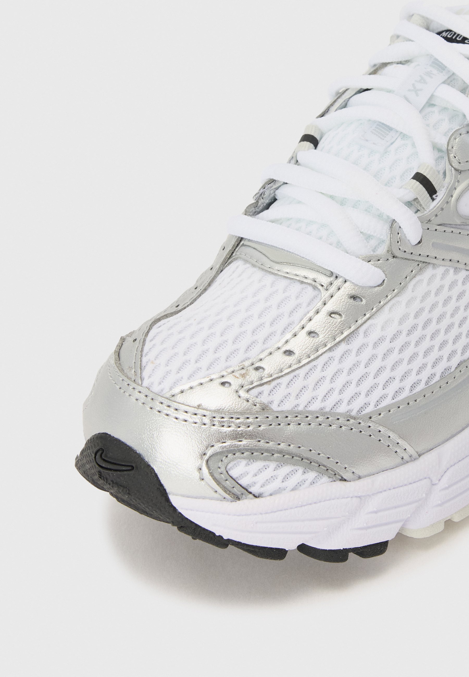 Sneaker feh&eacute;r h&aacute;l&oacute;s felsőr&eacute;sszel, ez&uuml;st szintetikus r&eacute;szletekkel &eacute;s textur&aacute;lt fekete gumitalppal. Feh&eacute;r cipőfűzővel ell&aacute;tva.