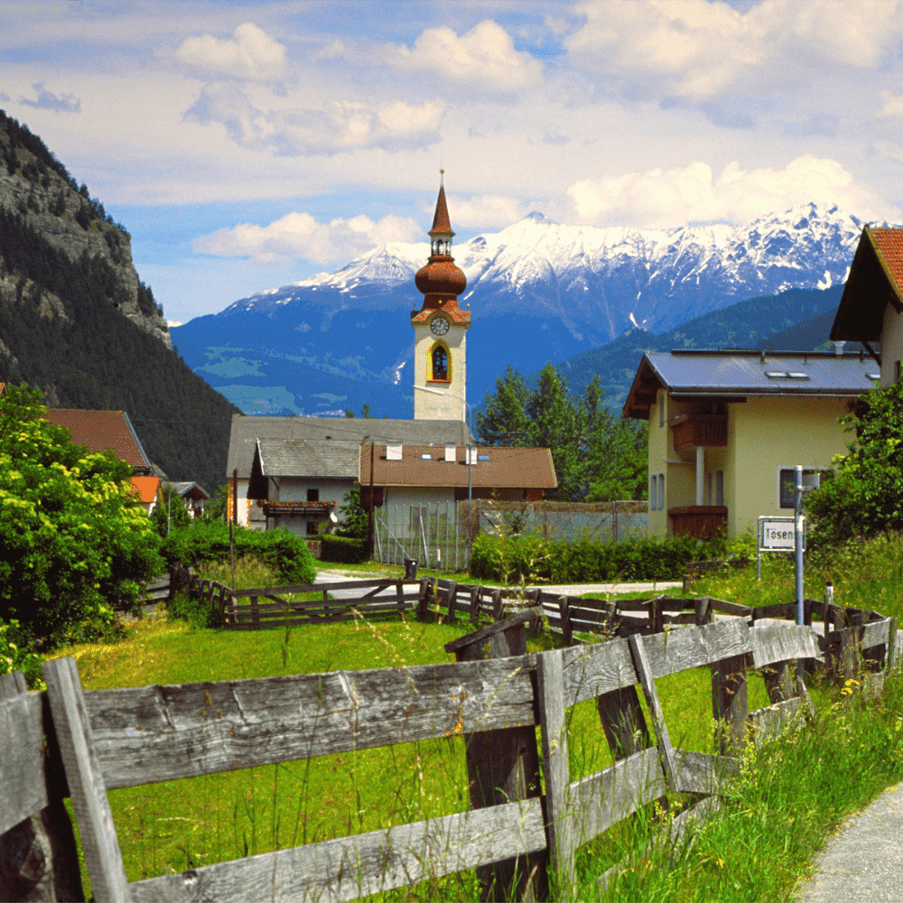 Austria eSIM – alpine village with church and snow-capped mountains, travel eSIM for Austria
