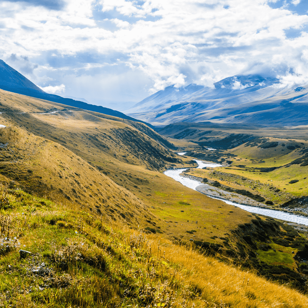 Kazakhstan eSIM – Tian Shan mountain valley with winding river and golden grasslands, travel eSIM for Kazakhstan
