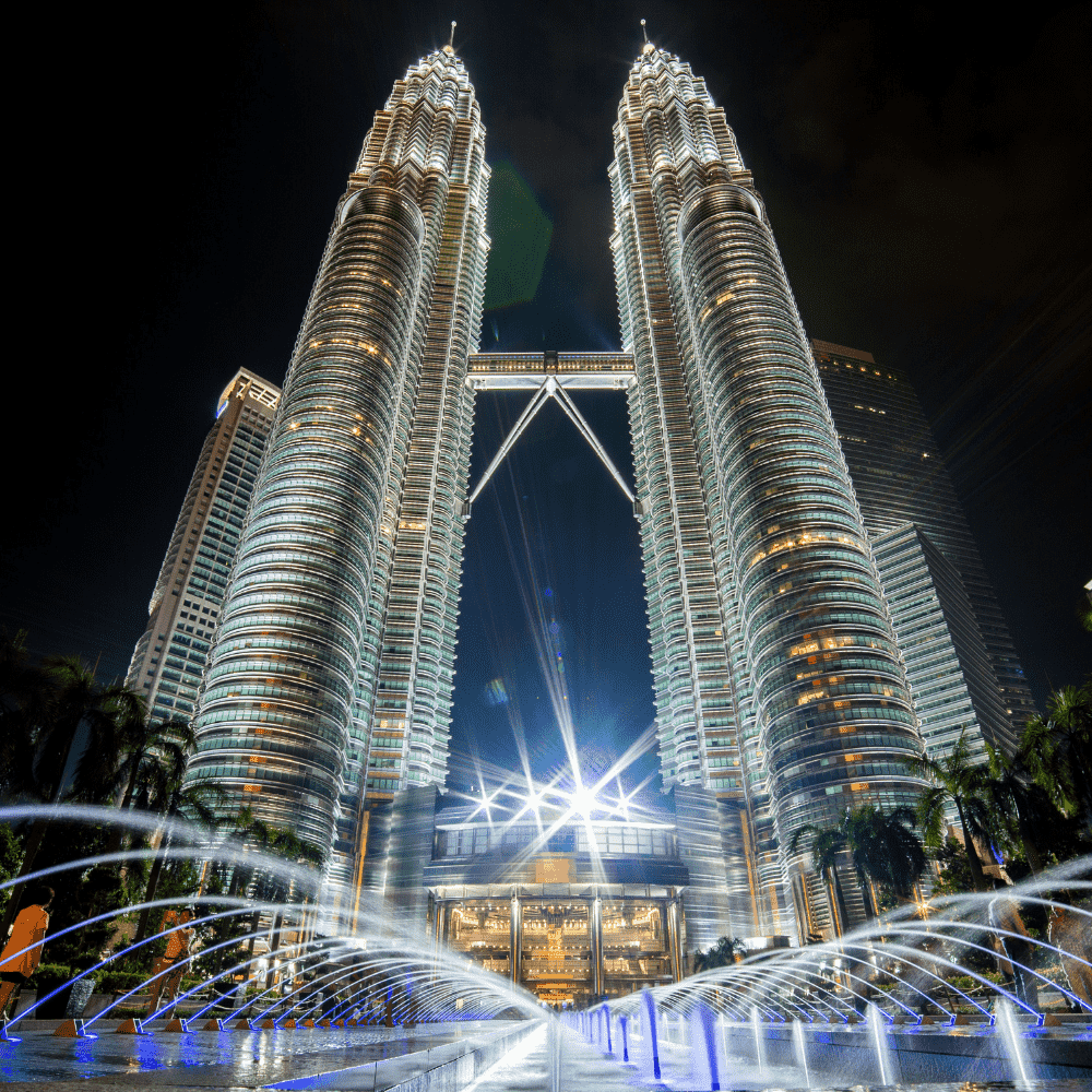 Malaysia eSIM – Petronas Twin Towers illuminated at night with fountain display in Kuala Lumpur, travel eSIM for Malaysia
