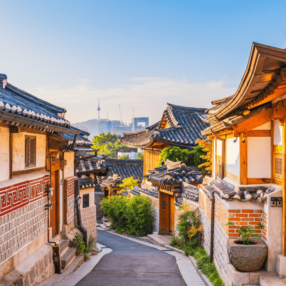 South Korea eSIM – Traditional Bukchon Hanok Village alley with historic Korean houses and N Seoul Tower in the background, travel eSIM for South Korea
