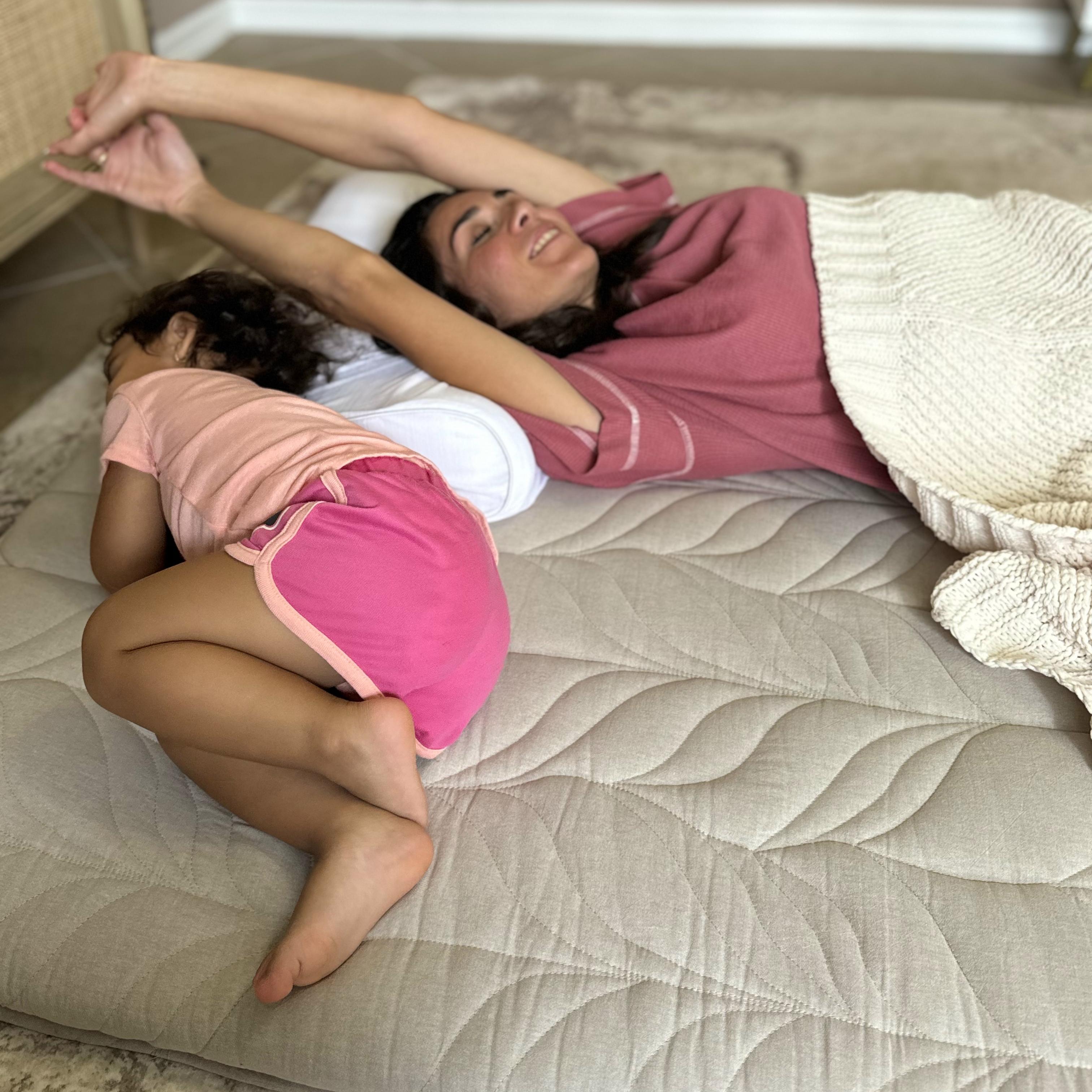 Baby is sleeping in the fetal position on a futon mattress