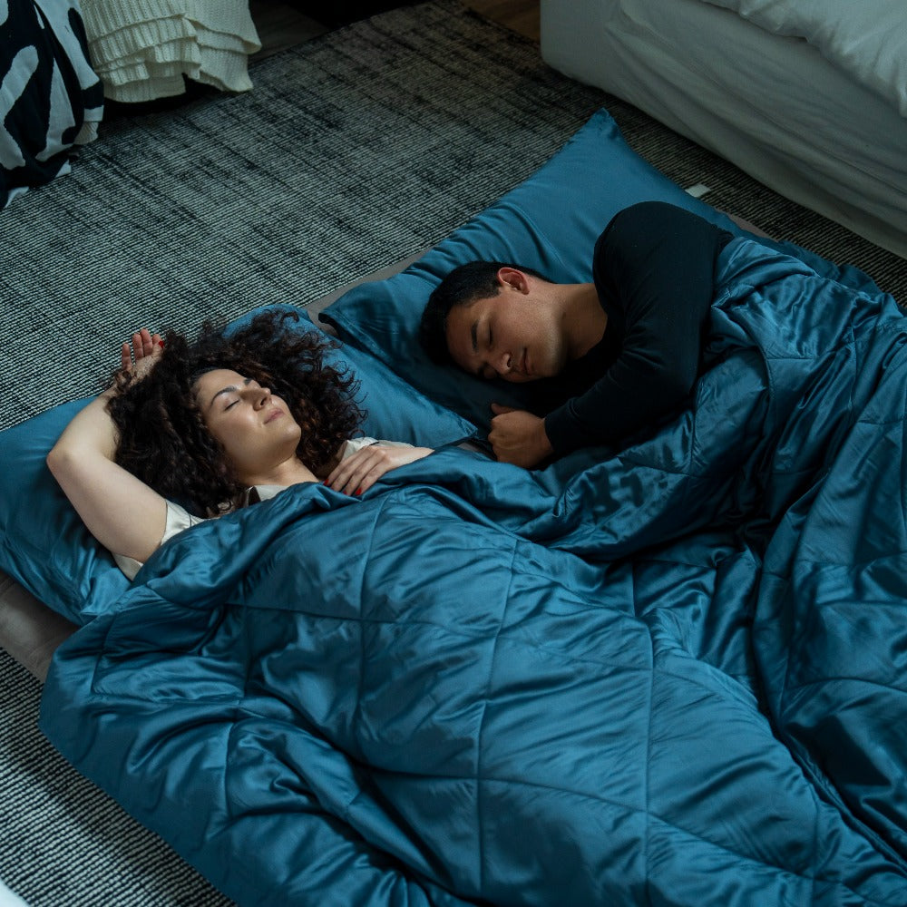 couple sleeping on futon mattress with cooling comforter