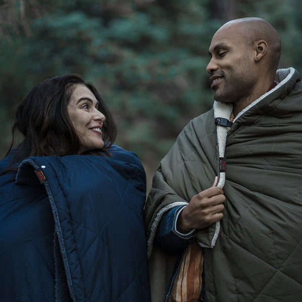 romantic couple camping with blanket