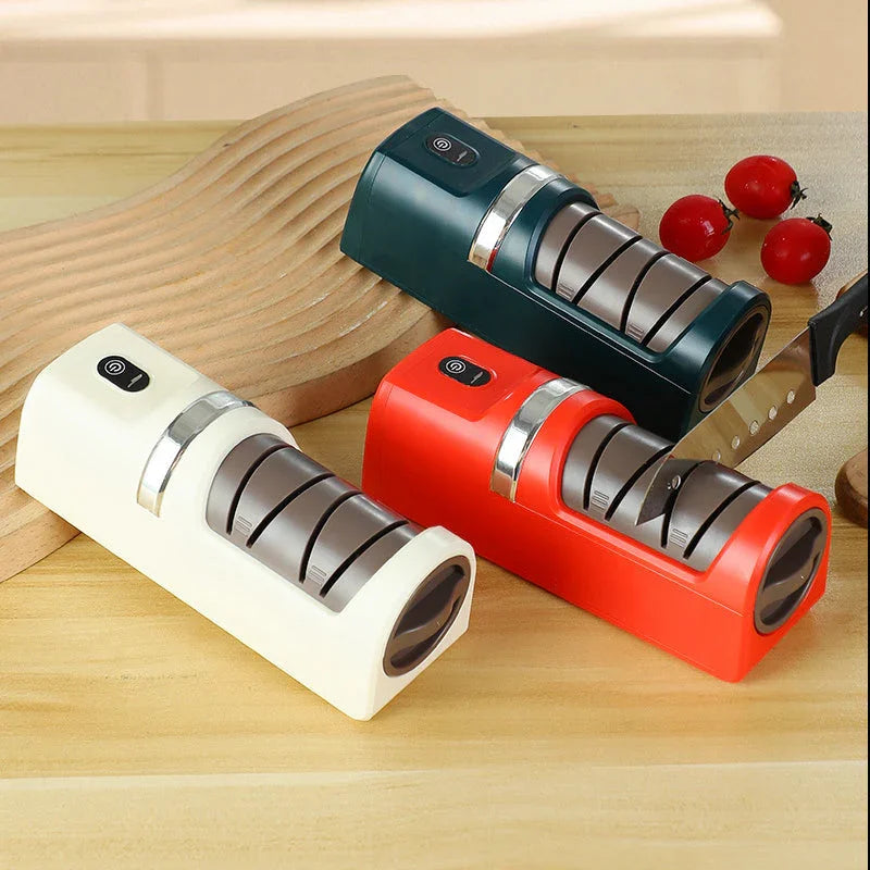 Set of three electric knife sharpeners in green, red, and white on kitchen countertop