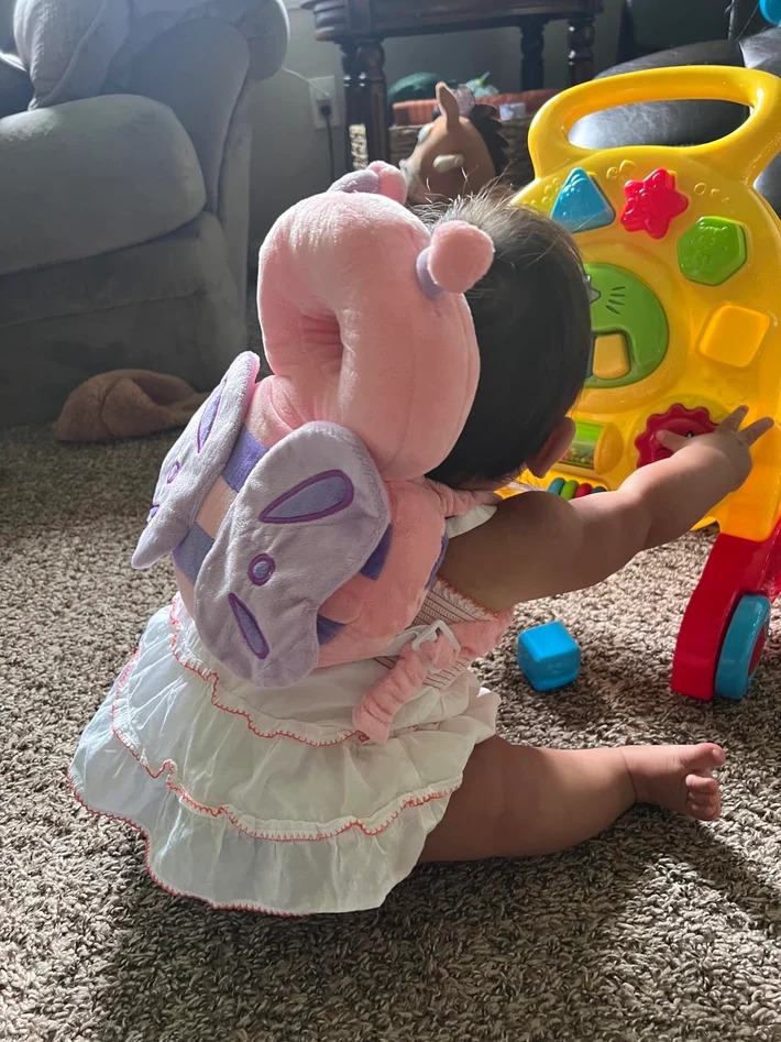 Customer photo of baby wearing the pink butterfly head protector