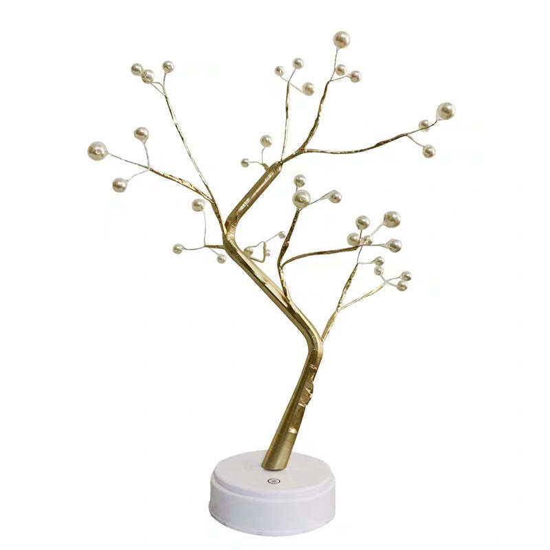 Decorative gold tree with pearls on a white base against a white background