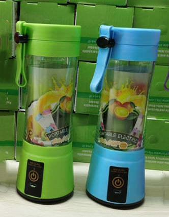 Two portable electric blenders, one green and one blue, on a white surface with a green box in the background.
