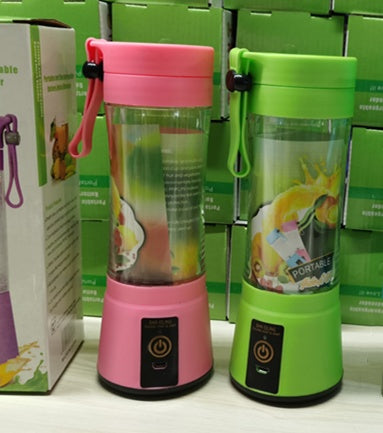 Pink and green portable blenders with colorful fruit images on a white surface.