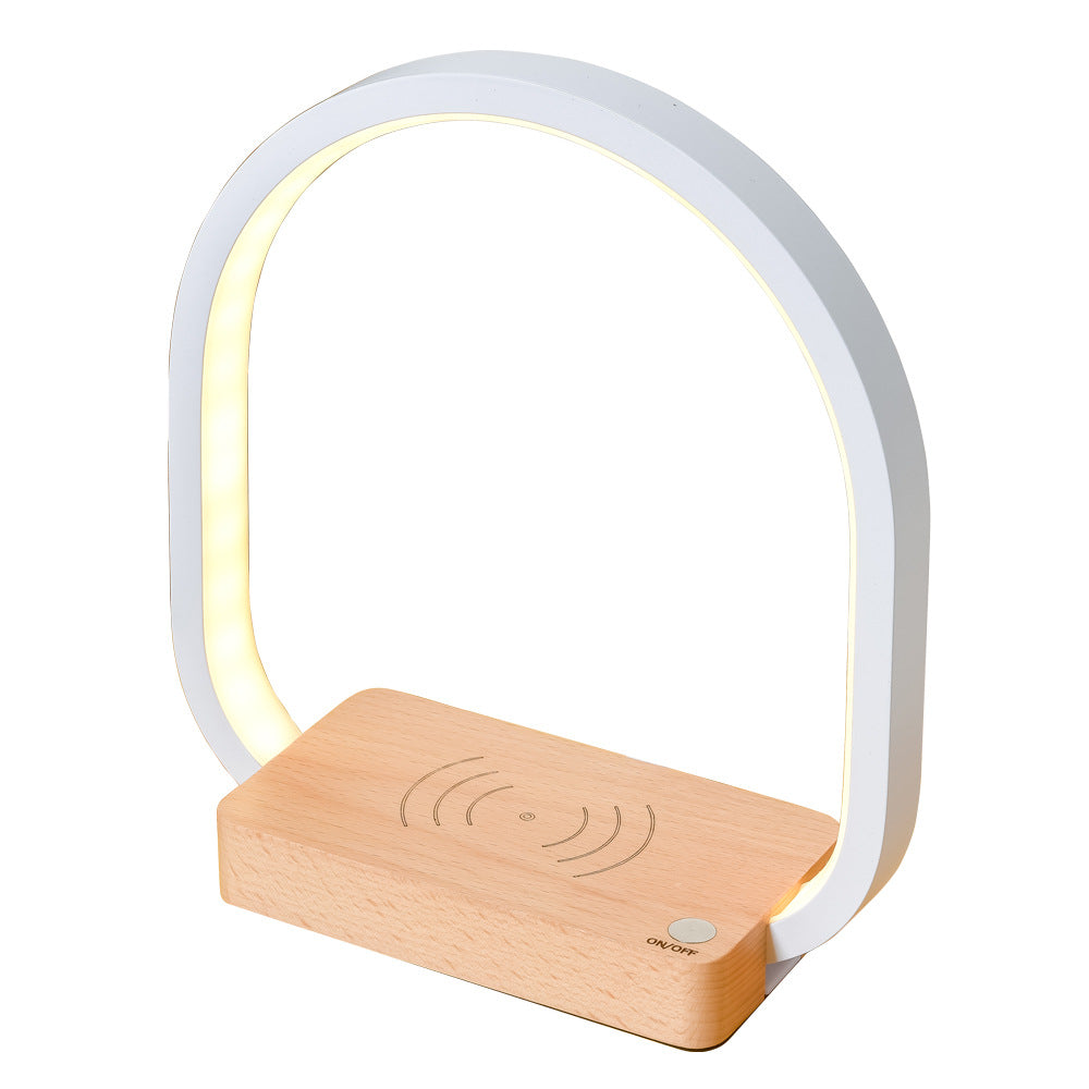 Modern table lamp with wooden base and white arch on a white background