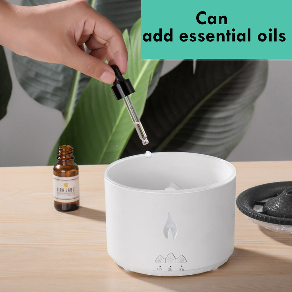 Person adding essential oils to a diffuser with a dropper, surrounded by greenery.