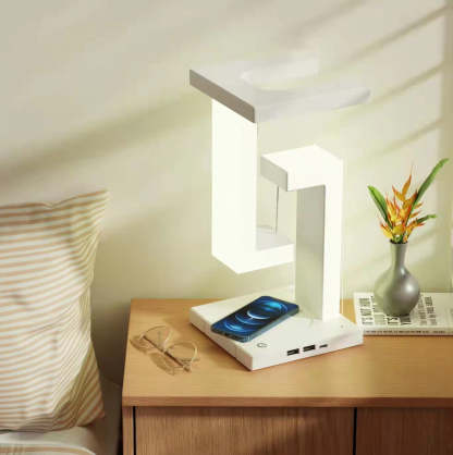 Modern table lamp on a bedside table with a smartphone and glasses.