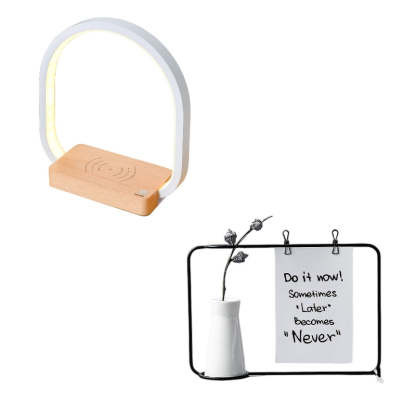 Small lamp with wooden base and white ring, next to a black frame with a motivational quote and a white vase.