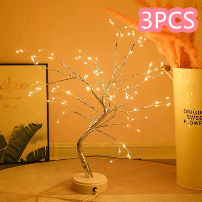 Decorative LED tree with lights on a wooden surface, next to a container labeled '3PCS'.