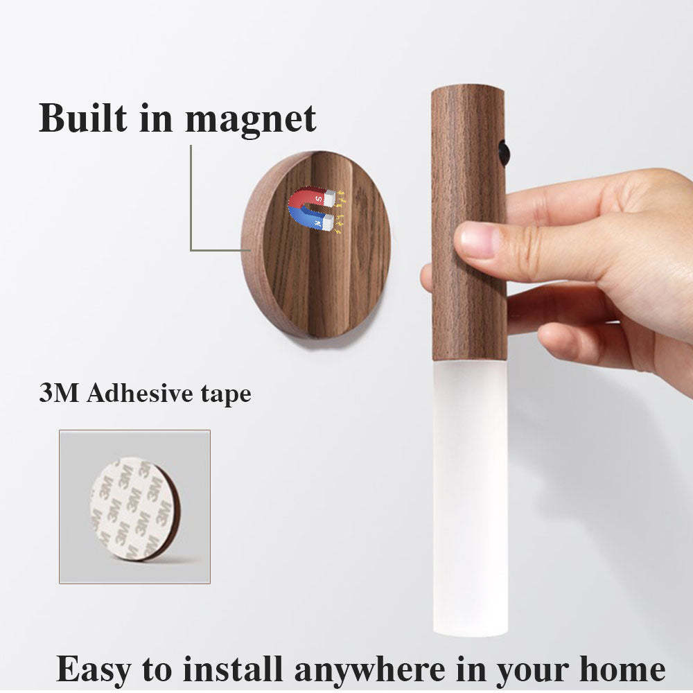 Wooden wall hook with magnetic attachment and adhesive tape, held by a hand.