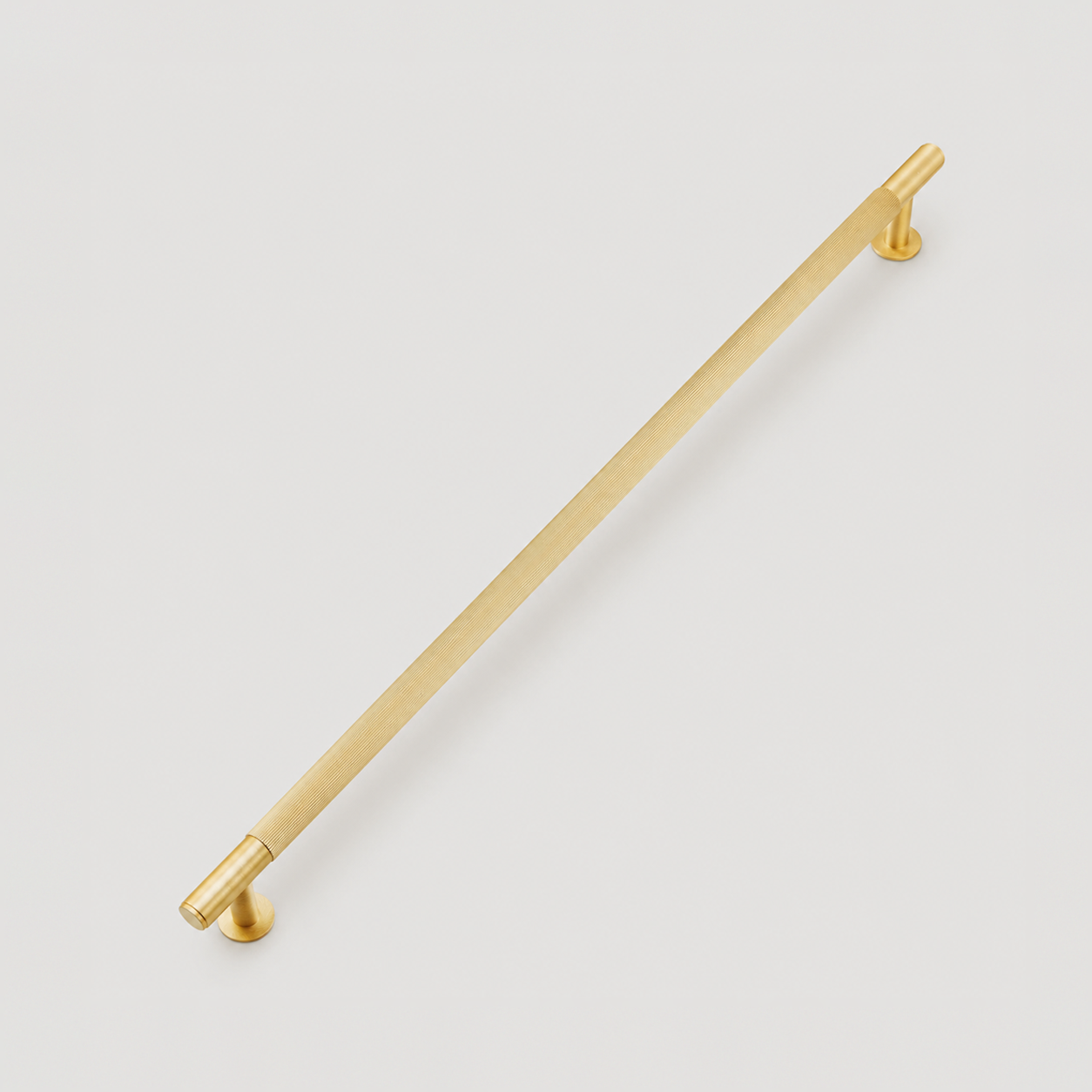 Fluted brass appliance pull with vertical reeded ridges in brushed brass
