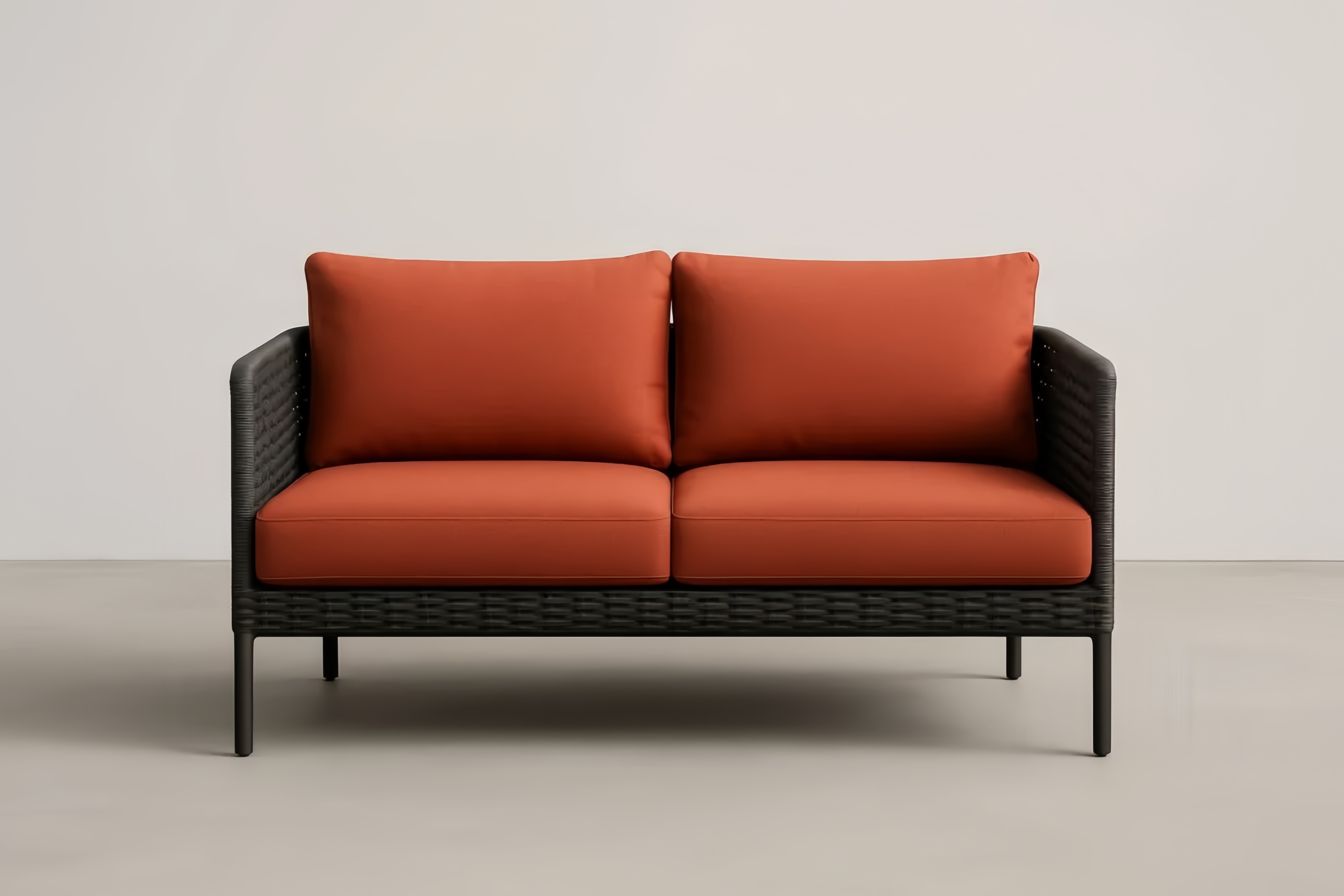 Dwuosobowa sofa z rattanu sztucznego czarna z pomarańczowymi poduszkami