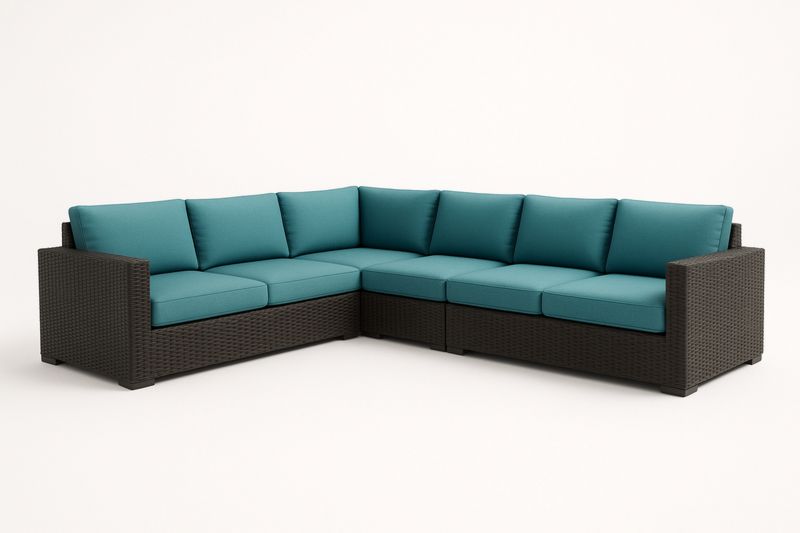 Narożna sofa z technorattanu z turkusowymi poduszkami