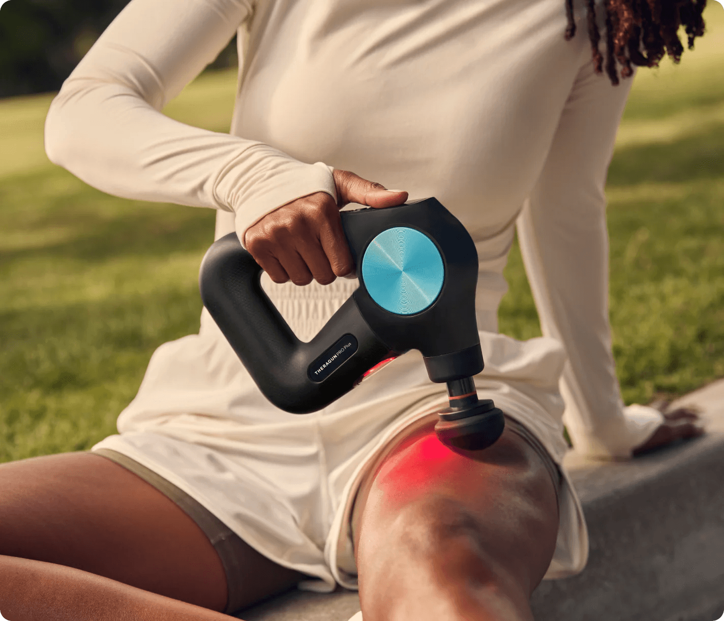 Woman using the Massage Gun Theragun PRO Plus with Heat Attachment on her thigh