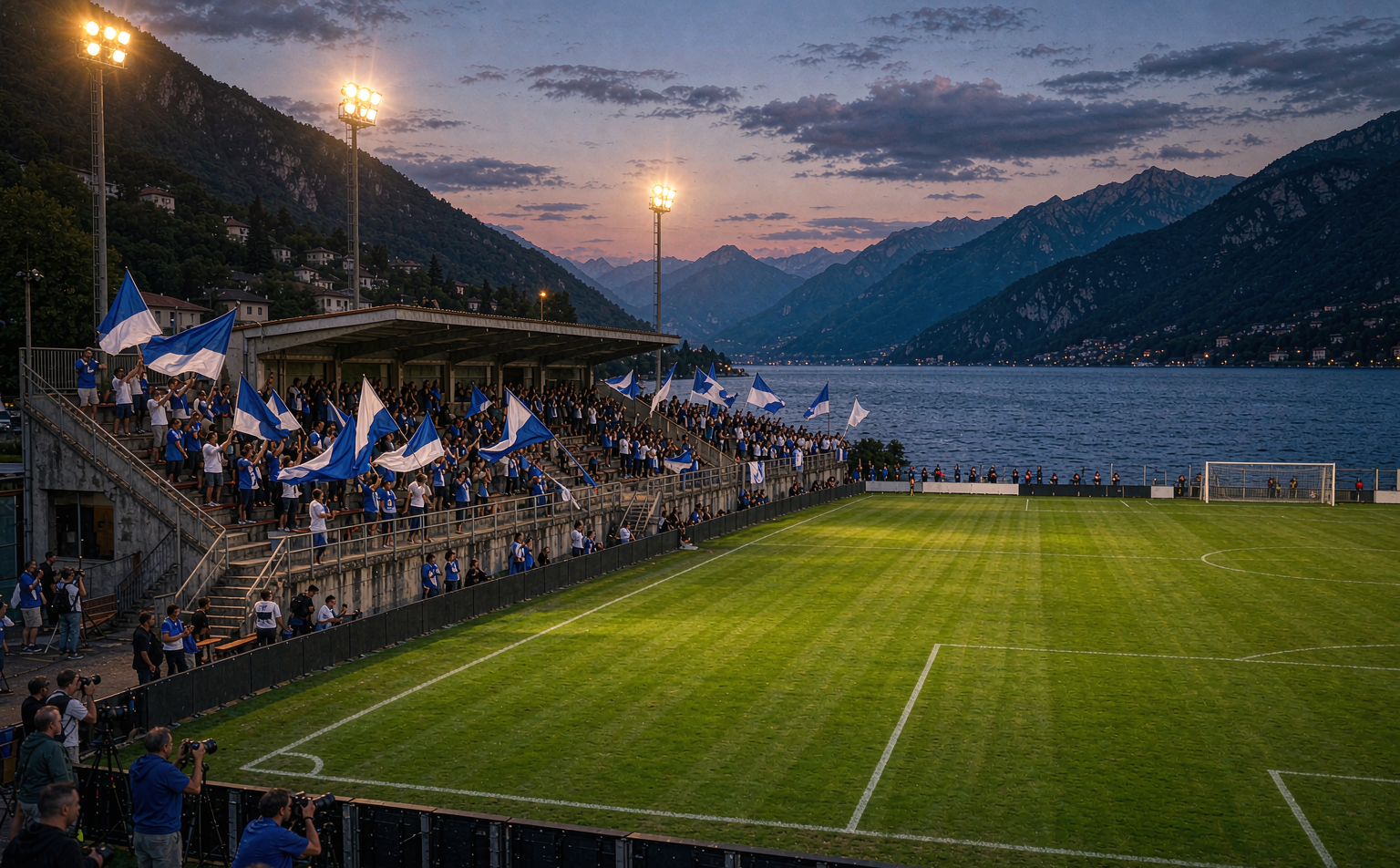 Stadio Giuseppe Sinigaglia on the shores of Lake Como at dusk with blue and white flags