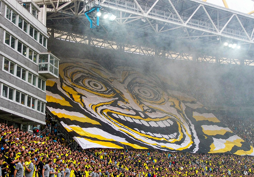 Borussia Dortmund fans at Signal Iduna Park with yellow and black flags on the Yellow Wall