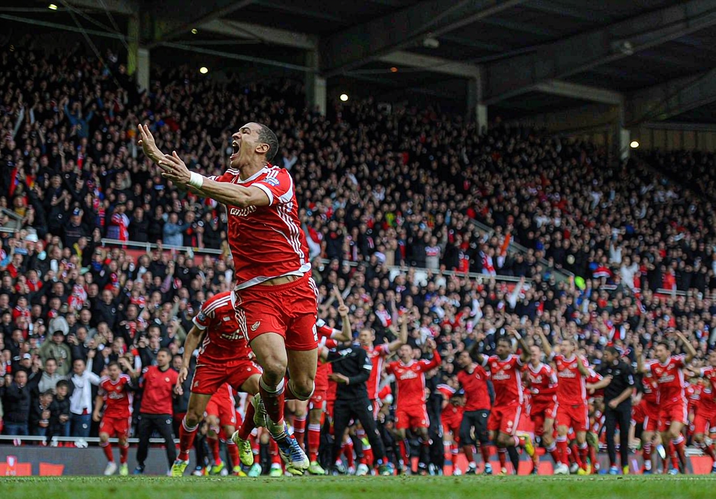 Arsenal player celebrating a goal in front of the North Bank